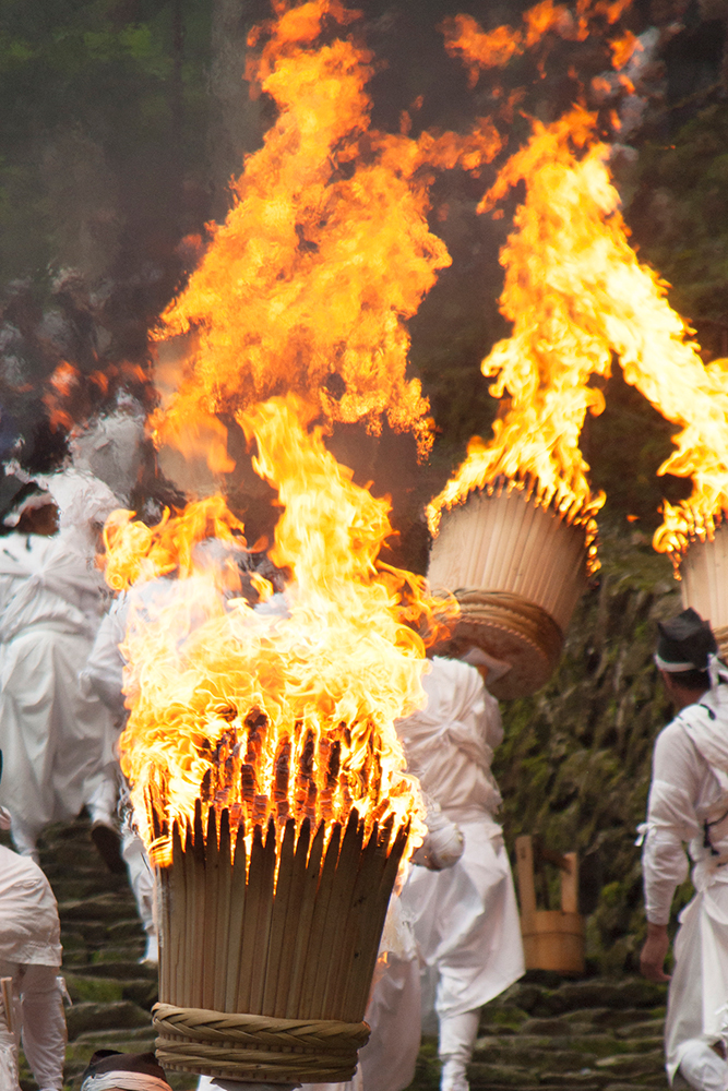 那智の火祭 松明には火が点けられ、参道の石段を登る様子